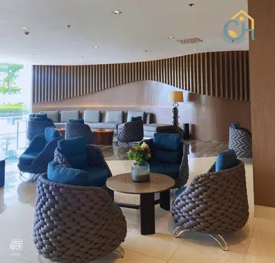 a hotel lobby with blue chairs and a table at Mall of Asia Condohotel located in Shore Residences Pasay in Manila