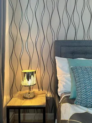 a bed with a table with a lamp on it at 1BR Condotel in Azure Urban Resort Near NAIA #TRO3 in Manila