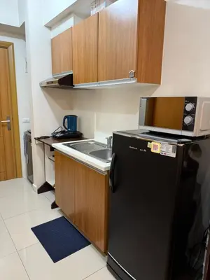 a kitchen with a black refrigerator and a sink at 8 Adriatico Manila in Manila