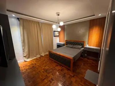 a bedroom with a bed and a wooden floor at 4BR Townhouse w Garage, Peaceful near Restaurants in Manila
