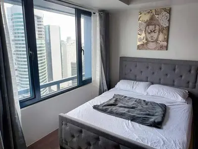 a bedroom with a bed with a large window at Apartment in quezon city in Manila