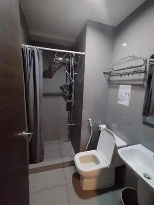 a bathroom with a shower and a toilet and a sink at Apartment in quezon city in Manila