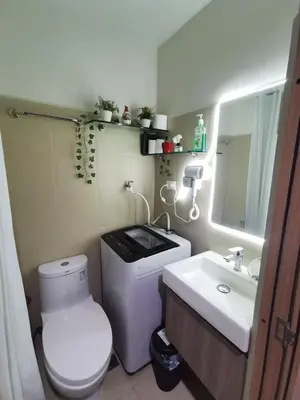 a bathroom with a white toilet and a sink at Mall of Asia condotel shore 3 residence in Manila