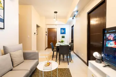 a living room with a couch and a table at Florence Mc Kinley Spacious 2 Bedroom, 2 balcony nr Mall, T3 airport in Manila