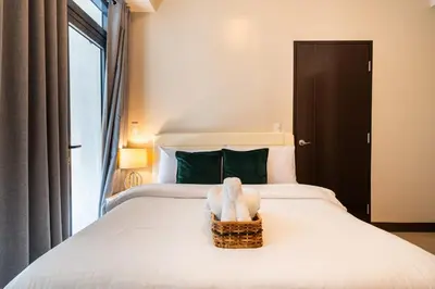 a bed with a basket with a stuffed animal on it at Florence Mc Kinley Spacious 2 Bedroom, 2 balcony nr Mall, T3 airport in Manila