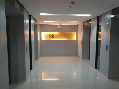 a hallway of an office building with a clock on the wall at Elevated cozy loft studio in Manila