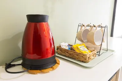 a red appliance on a shelf with a basket of dishes at Apartment in Pasay, close to Mall Of Asia in Manila