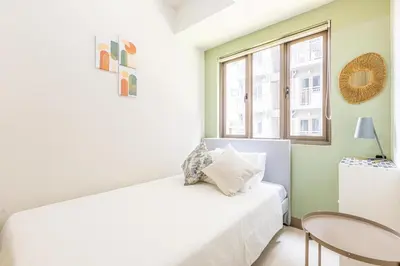 a bedroom with a white bed and a window at Apartment in Pasay, close to Mall Of Asia in Manila