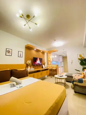 a hotel room with two beds and a living room at Shore Urban Escape in Manila