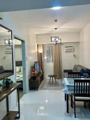 a living room with a dining table and a living room at High and Cozy Vista Shaw in Manila