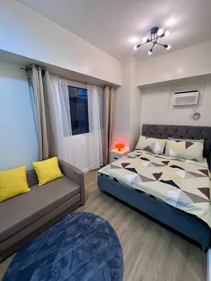 a bedroom with a bed and a couch at High and Cozy Vista Shaw in Manila