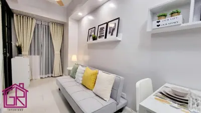 a living room with a white couch and a table at Stylish Modern Condo at Shore Residences MOA in Manila