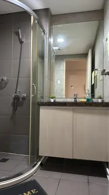 a bathroom with a shower and a sink and a mirror at AyenStaycation in Manila