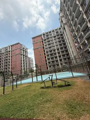 a bench in the grass in front of two tall buildings at AyenStaycation in Manila