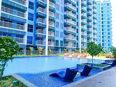 a swimming pool in front of a large apartment building at Lovely 1BR w Sunset near Solaire, Okada, Airport in Manila