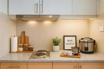 a kitchen counter with a stove and a sign on it at Cozy 1BR near Solaire, Okada, Mall of Asia in Manila