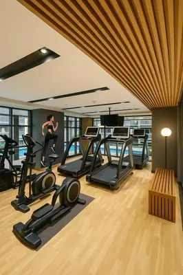 a gym with treadmills and a woman running on a treadmill at Cozy 1BR near Solaire, Okada, Mall of Asia in Manila