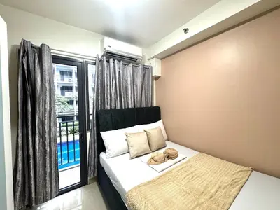 a bedroom with a bed and a large window at Shore 2 Residences Room 360 POOL VIEW by Prime Stay MOA in Manila