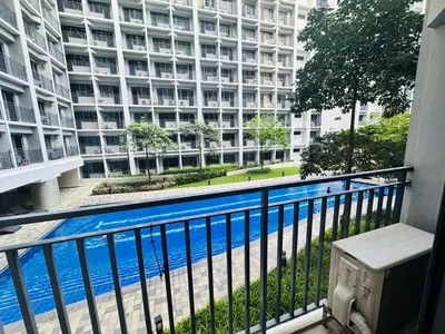a balcony with a view of a large building at Shore 2 Residences Room 360 POOL VIEW by Prime Stay MOA in Manila
