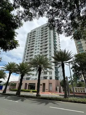 a tall building with palm trees in front of it at Stunning flat in Alabang in Manila