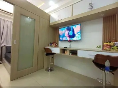 a room with a bar with a tv on a wall at Cozy Couple Room near mall of asia in Manila