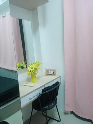 a black chair sitting in front of a mirror at Cozy Couple Room near mall of asia in Manila