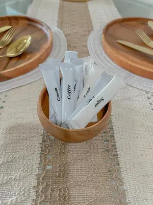 a wooden bowl filled with plastic utensils on a table at The Sandscape Suite in Manila