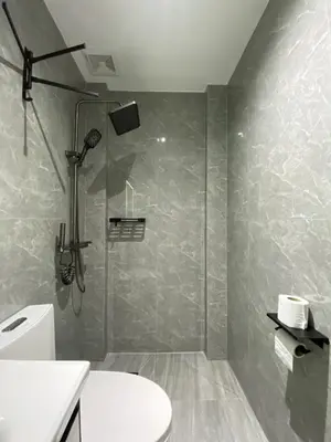 a bathroom with a shower and a toilet at BuenaSentro Hostel in Manila