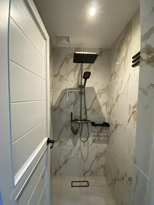 a bathroom with a shower with a shower head at BuenaSentro Hostel in Manila