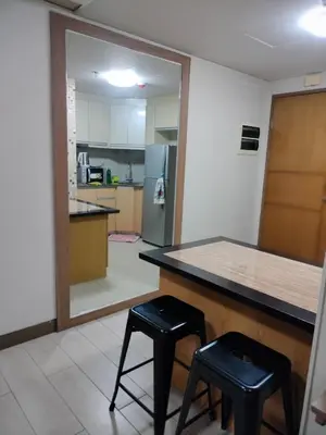 a kitchen with a counter and two stools and a mirror at Rooms Near Airport-Rqui in Manila