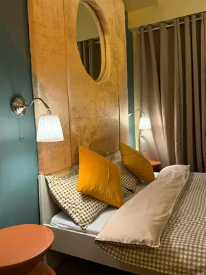 a bed with yellow pillows on it with a mirror at Serenity Stays at Red Residences in Manila