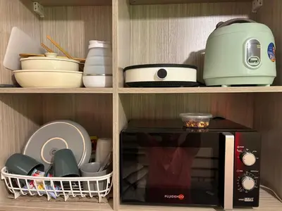 a kitchen with a microwave and plates and dishes at Urban Deca Tower Cubao - Affordable Condo Unit for Transient in Manila