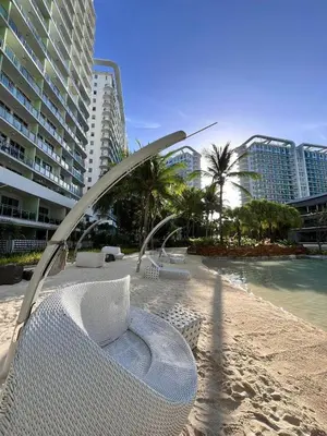 a chair on a beach next to some buildings at Azure Staycation by Leojen in Manila