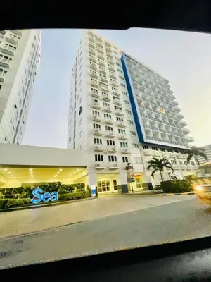 a large white building with a sign in front of it at Simple Staycay in Manila