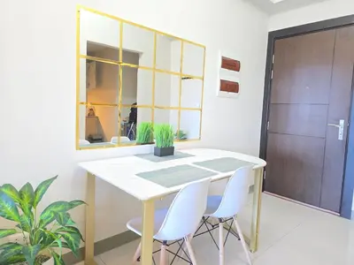 a dining room with a table and two white chairs at BGC Uptown Parksuites Cosy 1 Bedroom Suite with balcony 300MBPS wifi in Manila