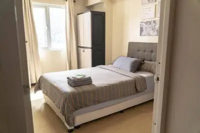 a bedroom with a bed in a room with a window at 1BR-unit in central BGC in Manila