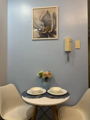 a table with two chairs and a picture on the wall at Azul Paradise in Manila