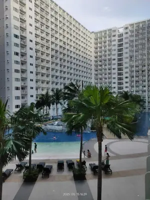 a view of a beach with palm trees and buildings at Shore Residences in Manila