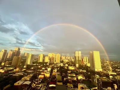a large city with a rainbow in the sky at Coast Residences Ivy in Manila