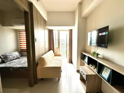 a small living room with a bed and a tv at Coast Residences Ivy in Manila