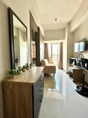 a living room with a desk and a living room with a couch at Coast Residences Ivy in Manila