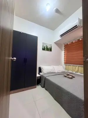 a bedroom with a bed and a sliding door at Coast Residences Ivy in Manila