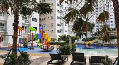 a playground with a slide in a building with palm trees at Staycation in Shore Residences, walking distance to MOA and near Manila Airport in Manila