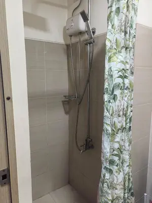 a shower in a bathroom with a shower curtain at Legit Staycation walking distance to Mall of Asia located in Shore1 and 2 Residences in Manila