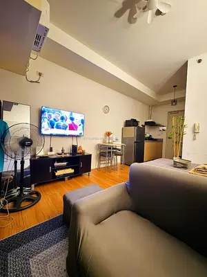 a living room with a couch and a flat screen tv at You Have VIN Here in Manila