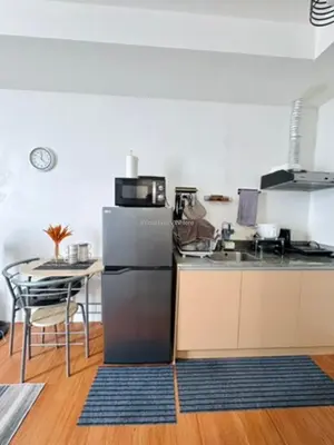 a kitchen with a stainless steel refrigerator and a table at You Have VIN Here in Manila