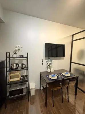 a dining room with two tables and a tv at Solace Haven in Manila