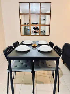 a black dining room table with chairs and a mirror at Danny's Haven Ortigas in Manila