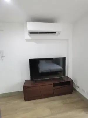 a flat screen tv sitting on top of a wooden entertainment center at Luxury Condo at Century Spire in Central Makati in Manila