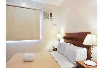 a hotel room with a bed and a window at Belvilla Airport Stays Near Makati Manila Formerly Avitel Hotel in Manila